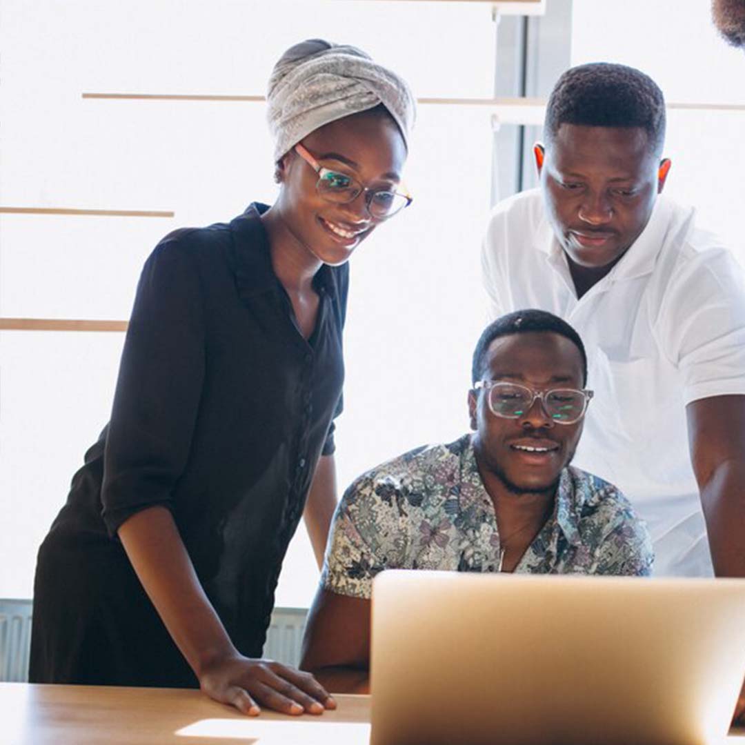 Three people working on laptop - SQ